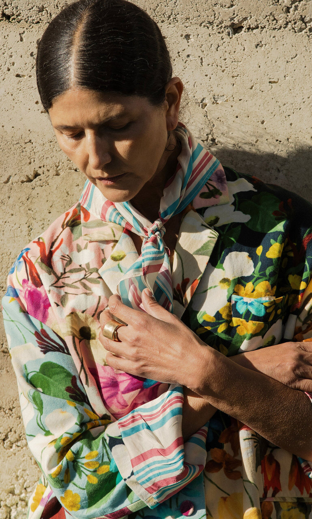 Plümo- Woman in a colorful floral robe, eyes closed, wears the Rimini Stripe Necktie around her neck.