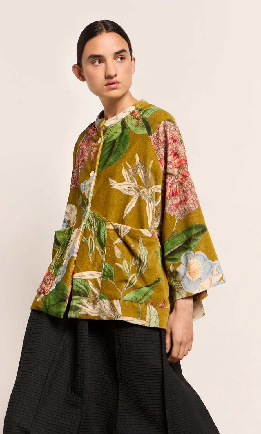 Plümo  Model in Rodart Velvet Jacket in green and yellow floral, paired with black textured pants.