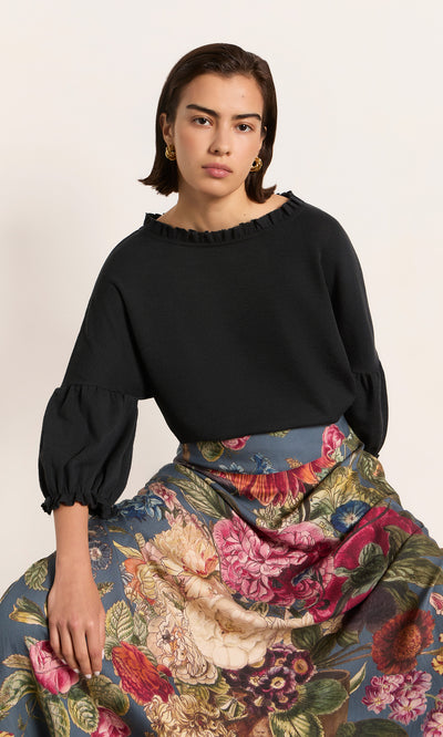 Plümo  Woman in the Ruffle Top – Caviar, showcasing elegant Danish design with ruffled sleeves and timeless style.