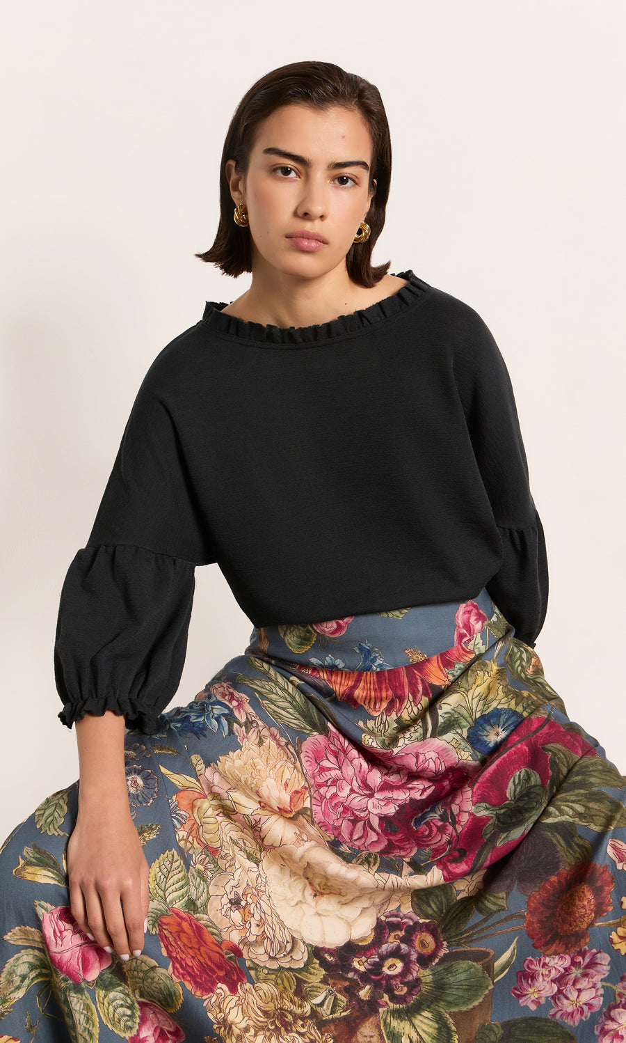 Plümo  Woman in the Ruffle Top – Caviar, showcasing elegant Danish design with ruffled sleeves and timeless style.