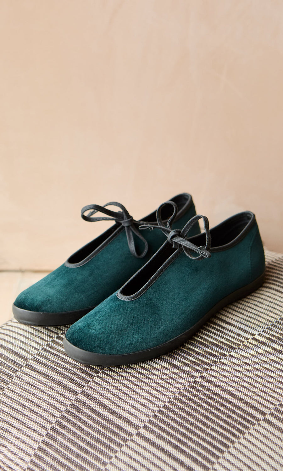 Plümo- Velvet Prim Ballerinas in teal with black soles and laces, displayed on a brown plaid fabric surface.