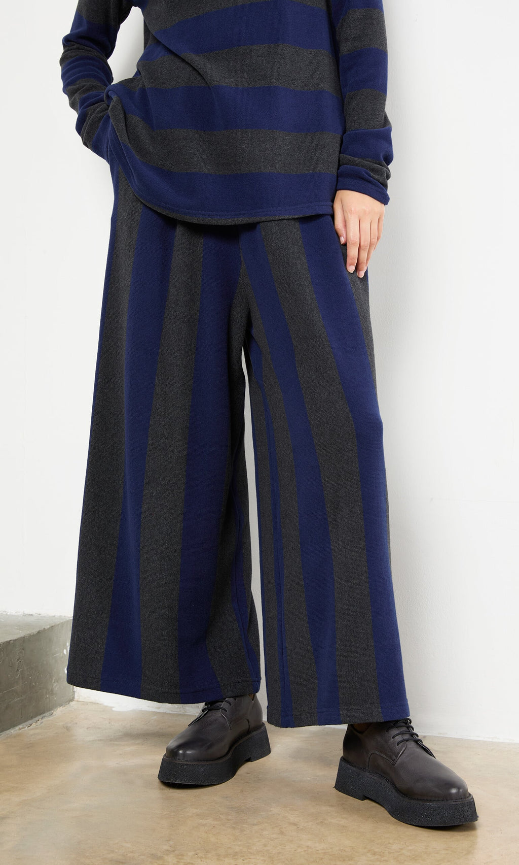 Plümo- Person wearing Clara Stripe Pants with a matching long-sleeve top, standing indoors.
