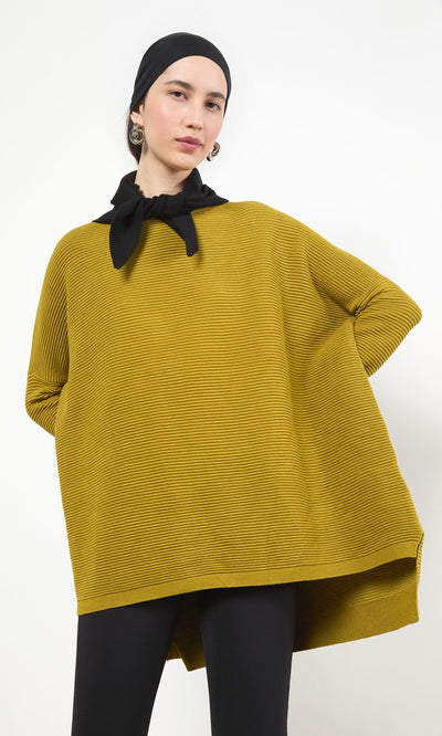 Plümo- Woman in a mustard yellow oversized top, Jona Necktie - Black, earrings, and black pants on a white background.