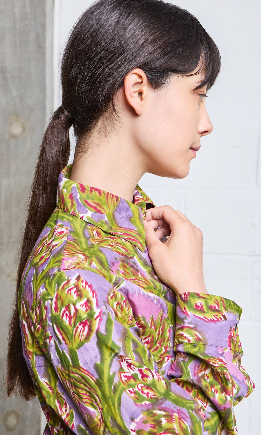 Plümo- Woman in profile adjusts collar of Artichoke Shirt, a block-printed cotton top handmade in India.