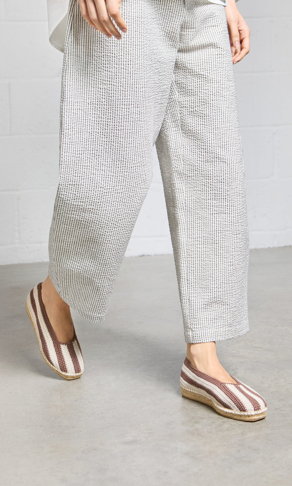 Plümo- Person wearing wide-legged, textured white pants and Basque Espadrilles with cushioned insoles on a gray floor.