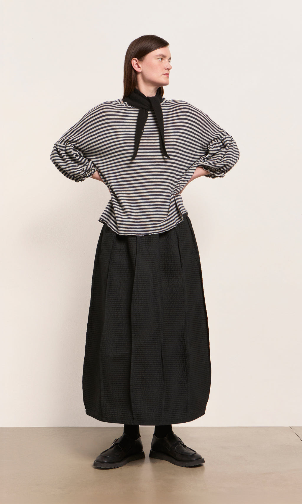 Plümo  Woman styles a striped long-sleeve top, black skirt, and the Black Cashmere Necktie for a chic winter look.