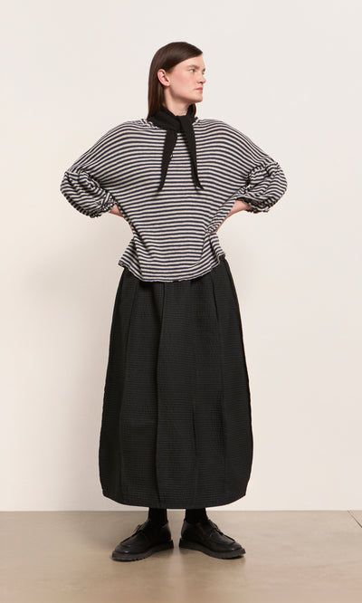 Plümo  Woman styles a striped long-sleeve top, black skirt, and the Black Cashmere Necktie for a chic winter look.