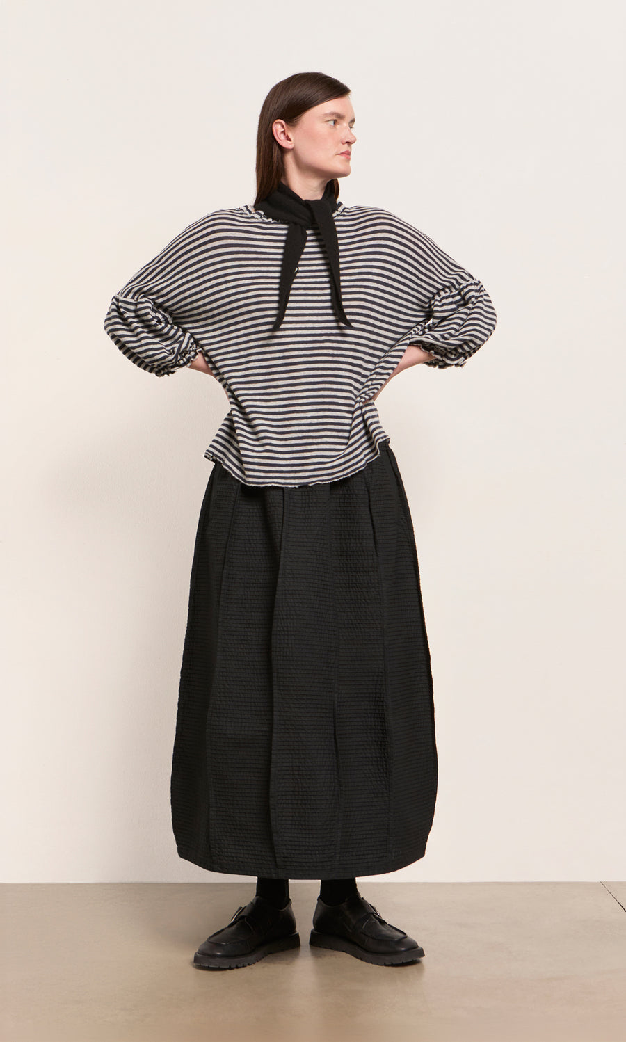 Plümo  Woman styles a striped long-sleeve top, black skirt, and the Black Cashmere Necktie for a chic winter look.