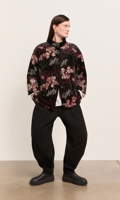 Plümo  Person in a Charone Jacket stands hands-in-pockets—a chic velvet choice for party season.