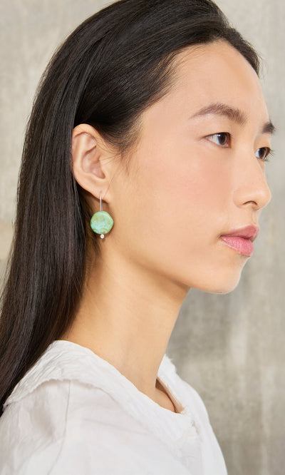 Plümo- Woman with long dark hair in a white top wears Erika Earrings, shown in profile against a neutral backdrop.