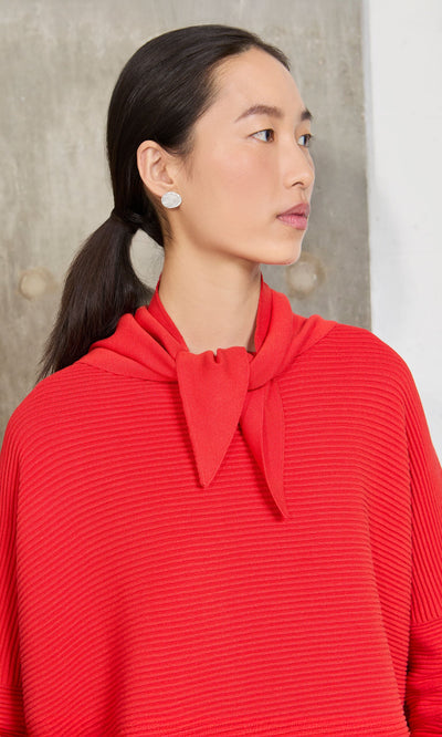 Plümo- Woman with long dark hair wears the Jona Necktie - Lava top and silver earrings.