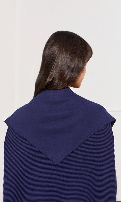 Plümo- A person with long dark hair wears a navy Jona Necktie featuring a distinctive triangular collar.