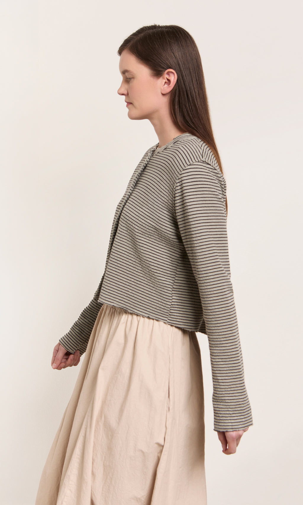 Plümo  Woman in a Lavelle Top and beige skirt stands in profile, showcasing eco-friendly materials and fair production.