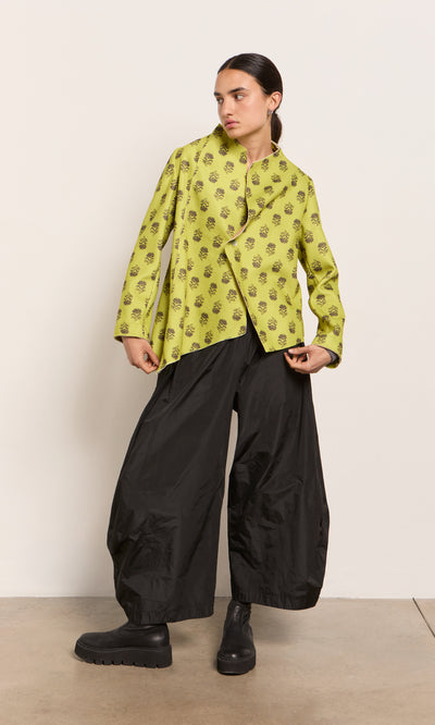 Plümo  Woman in the Leandra Jacket, a paisley block print style, with black wide-leg pants. Made in Italy.