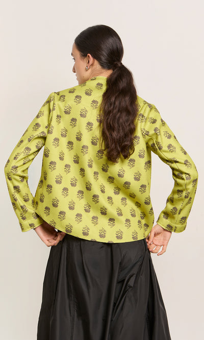 Plümo  Woman facing away in the Leandra Jacket, paisley block print, black skirt, long hair tied back, made in Italy.