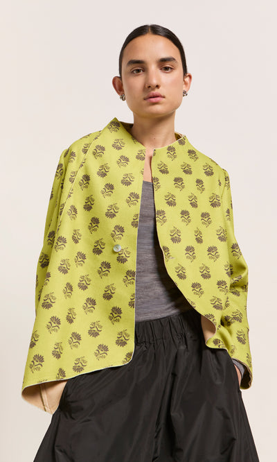 Plümo  Person wears the Leandra Jacket, a gray top, and black pants against a plain light background.
