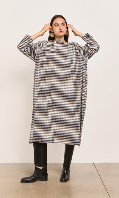 Plümo  Person in a Marsell Dress - Gingham, designed in London, pairs it with black knee-high boots.
