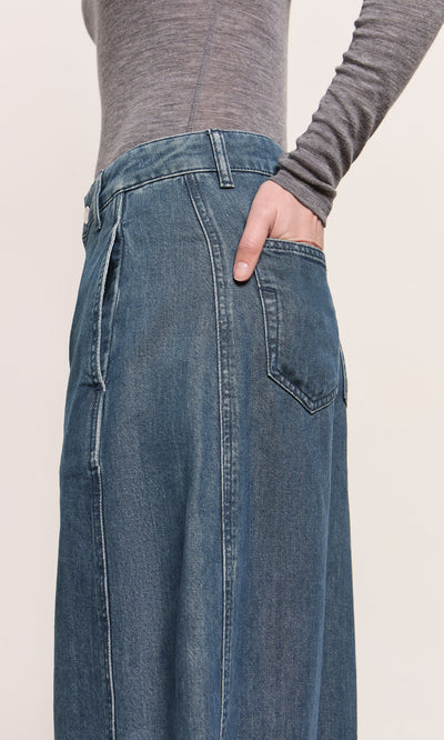 Plümo  A person in a gray long-sleeve shirt and Maud Barrel Pants with one hand in the back pocket.