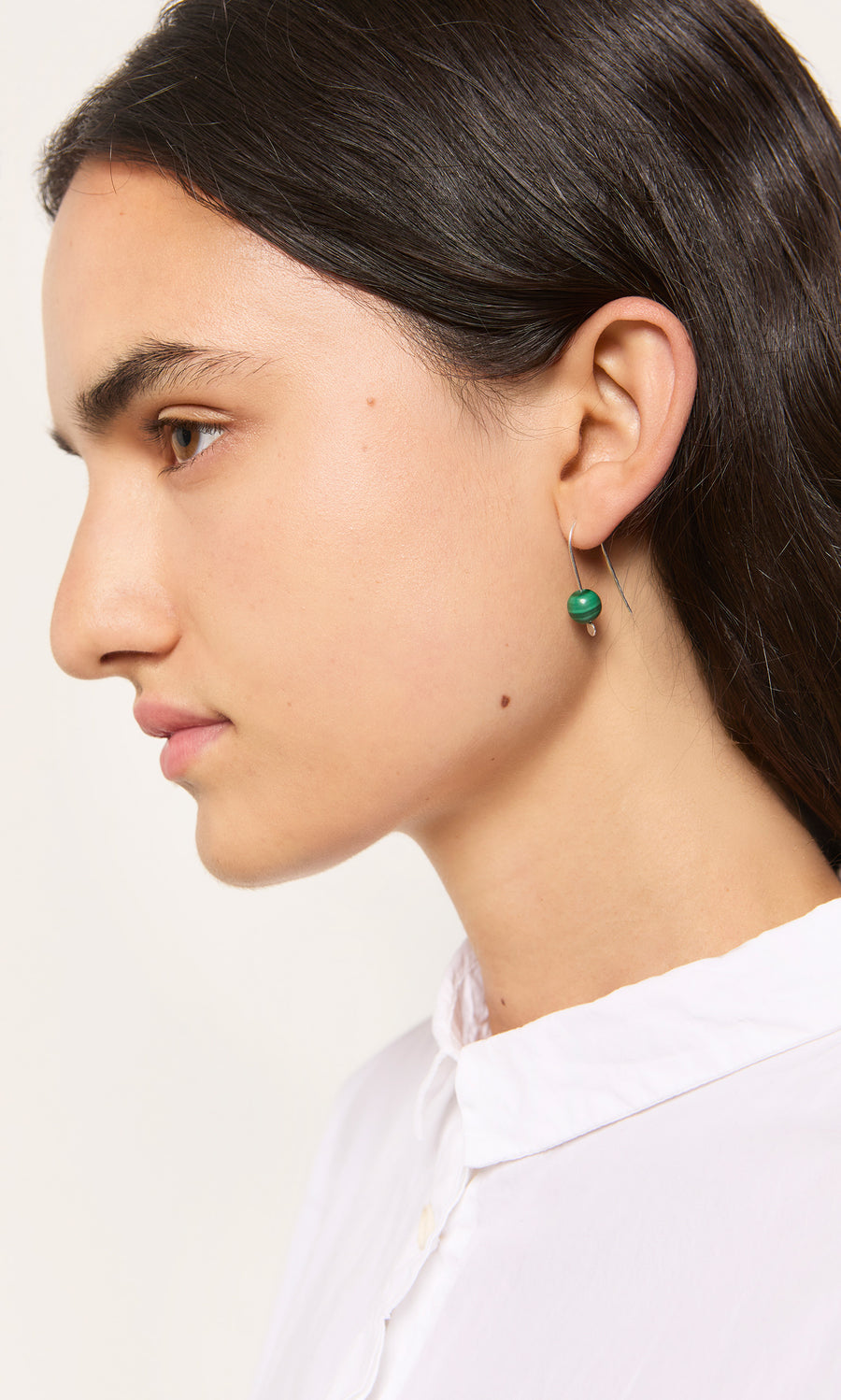 Plümo  Woman with long dark hair wears Karli Earrings, showcasing unique gemstone jewelry in profile.