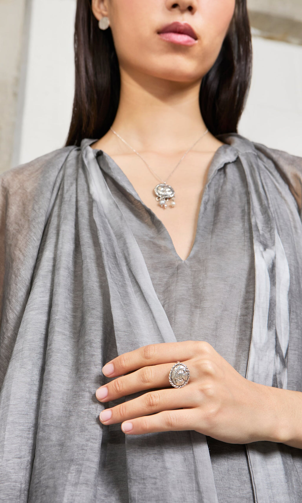 Plümo- Woman raises her hand, showcasing the Silver Wild Ring—a large handcrafted sterling silver statement piece.