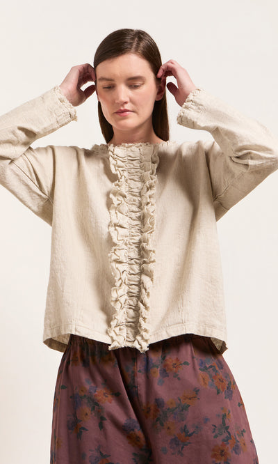 Plümo  Someone wears the Ella Ruffle Top and loose floral pants, standing against a plain light background.