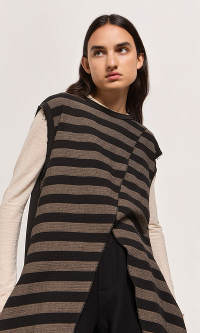 Plümo  Woman in the Venlo Stripe Tunic layered over a long-sleeve beige shirt, looking to the side.
