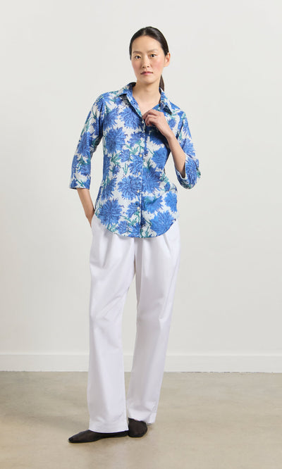 Plümo- Person wearing the Blue Thistle Shirt with shell buttons and white pants, standing against a light background.