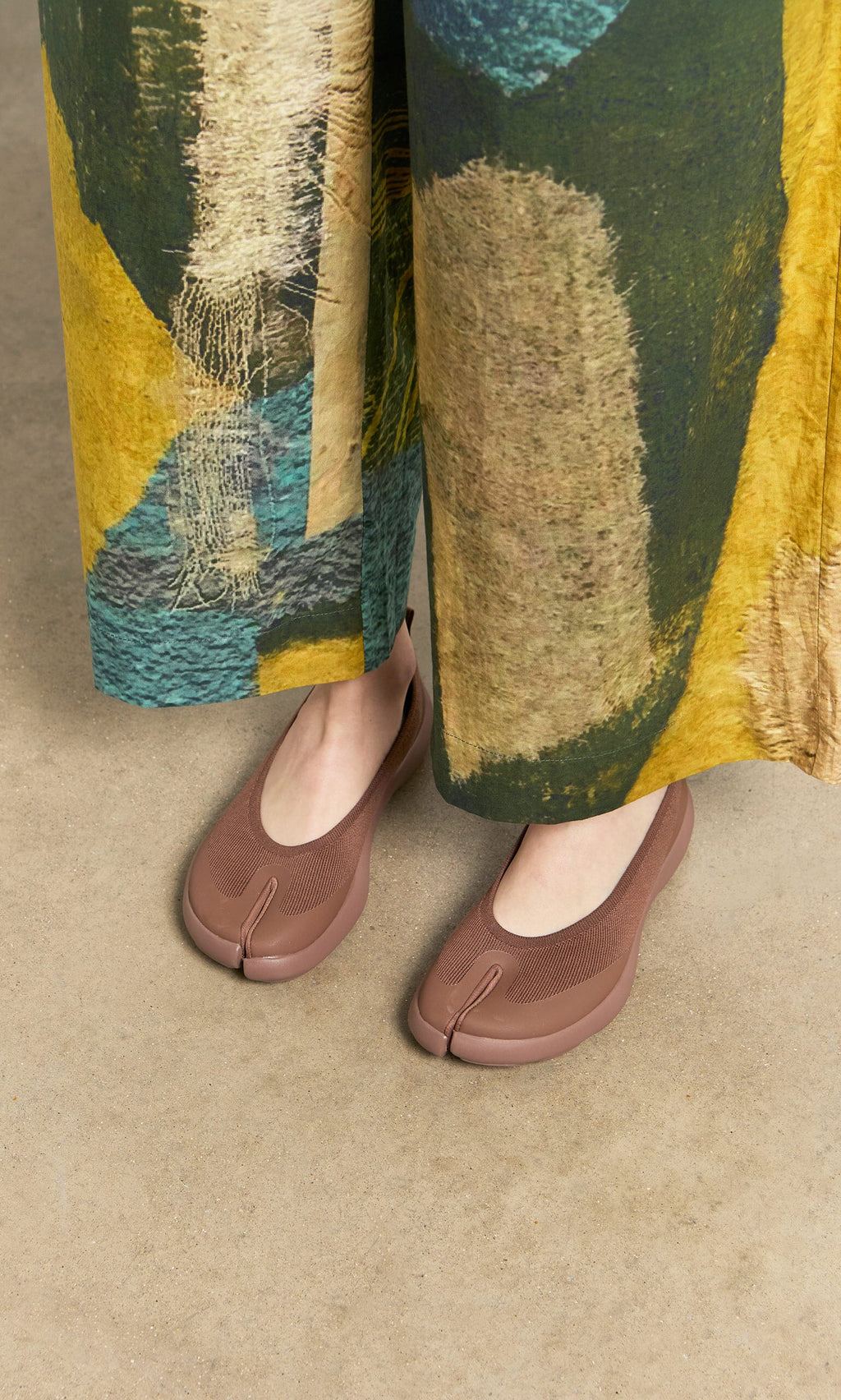 Plümo- Person wearing wide, colorful pants and Choco Tabi Ballerinas on a beige floor.