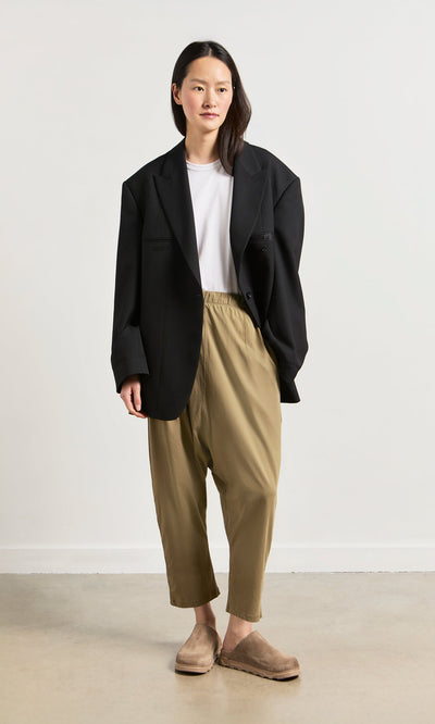 Plümo- A woman in Como Mules with a comfy moulded footbed stands against a plain background in chic, minimalist style.