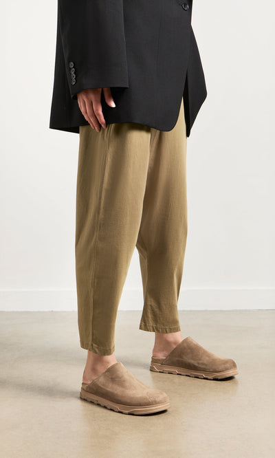 Plümo- Person wearing loose khaki pants, a black blazer, and taupe Como Mules with a comfy moulded footbed by Lofina.