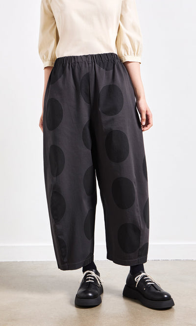 Plümo- Person wearing Easy Point Pants with large black polka dots, black shoes, and a cream top.