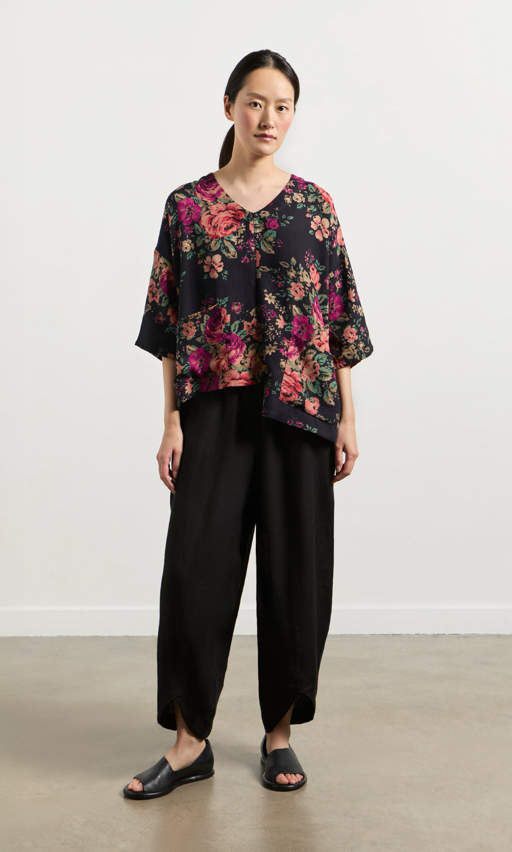 Plümo- Person wearing the Liu Pocket Blouse in Deep Navy, black wide-leg pants, and black sandals, standing indoors.