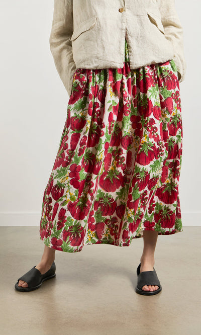 Plümo- Person wearing a beige jacket, Marzano Skirt, and black sandals, standing indoors.