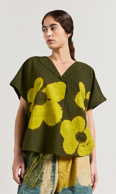 Plümo- Woman wearing the Orta Blouse in a relaxed fit with an oversized floral pattern, paired with a multicolored skirt.