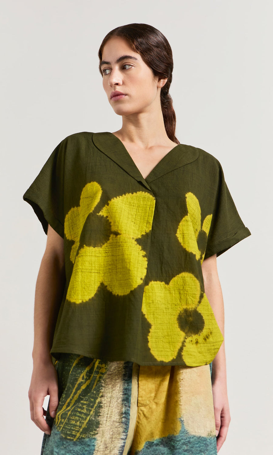 Plümo- Woman wearing the Orta Blouse in a relaxed fit with an oversized floral pattern, paired with a multicolored skirt.