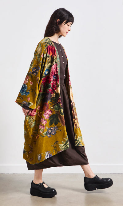 Plümo- Woman wears the Pomfret Kimono over a brown dress with black platform shoes against a plain white background.