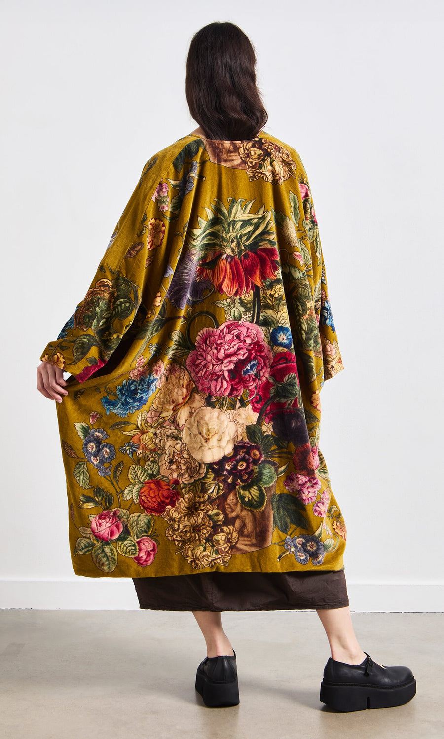 Plümo- Person standing with their back to the camera, wearing the Pomfret Kimono and black platform shoes.