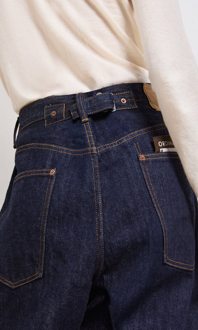 Plümo- Person wearing Japanese Raw Denim Jeans and a cream long-sleeve top, shown from the back highlighting the jeans’ pockets.