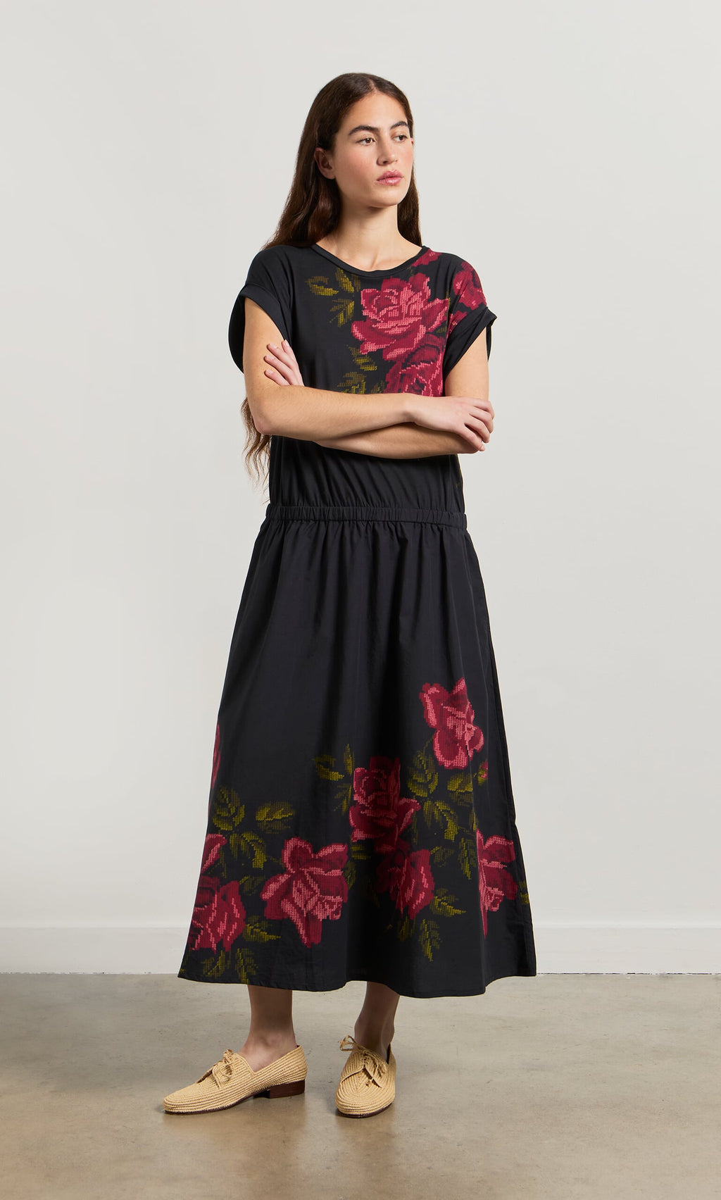Plümo- Woman in the Rose Stitch Dress with large red florals and beige woven shoes featuring a cross-stitch rose design.