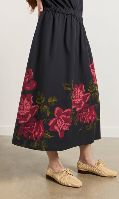 Plümo- A person wears the Rose Stitch Dress and beige woven shoes, standing on a light floor.
