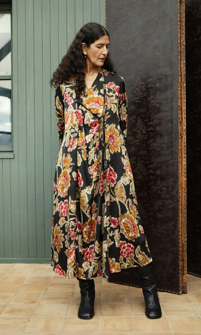 Plümo  Woman in the Brunn Dress and black boots stands on tile indoors, looking right. Plümo Studio style.
