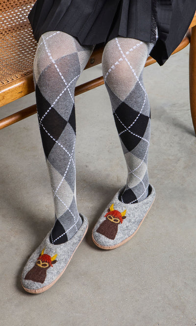 Plümo- Person wearing gray argyle tights and Highland Slippers, sitting on a wooden bench.