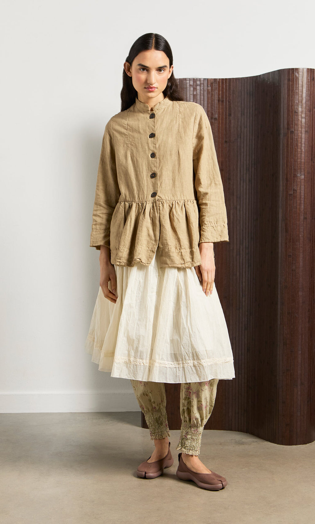 Plümo- Woman in a brown jacket and printed pants showcases Choco Tabi Ballerinas, blending Japanese design and comfort.