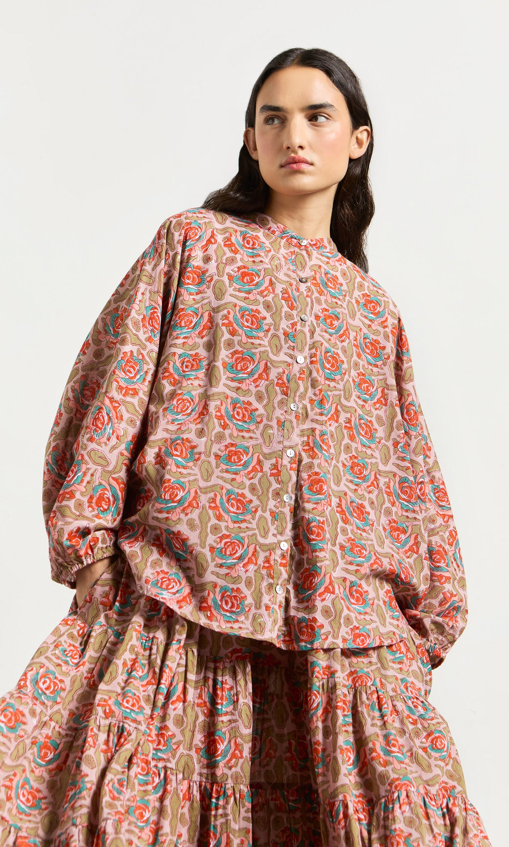 Plümo- Woman in the Lotus Flower Blouse, a loose, long-sleeved floral top made from ethically crafted block-printed cotton.