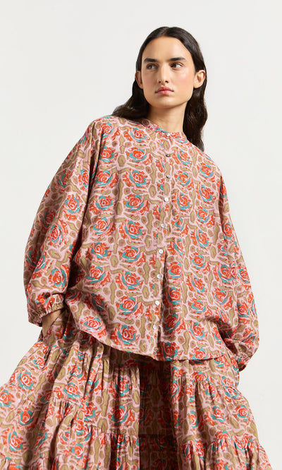 Plümo- Woman in the Lotus Flower Blouse, a loose, long-sleeved floral top made from ethically crafted block-printed cotton.