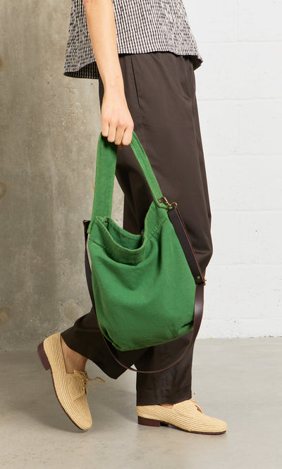 Plümo- Person with the Selva Canvas Bag, wearing brown pants, woven shoes, and a checked shirt.