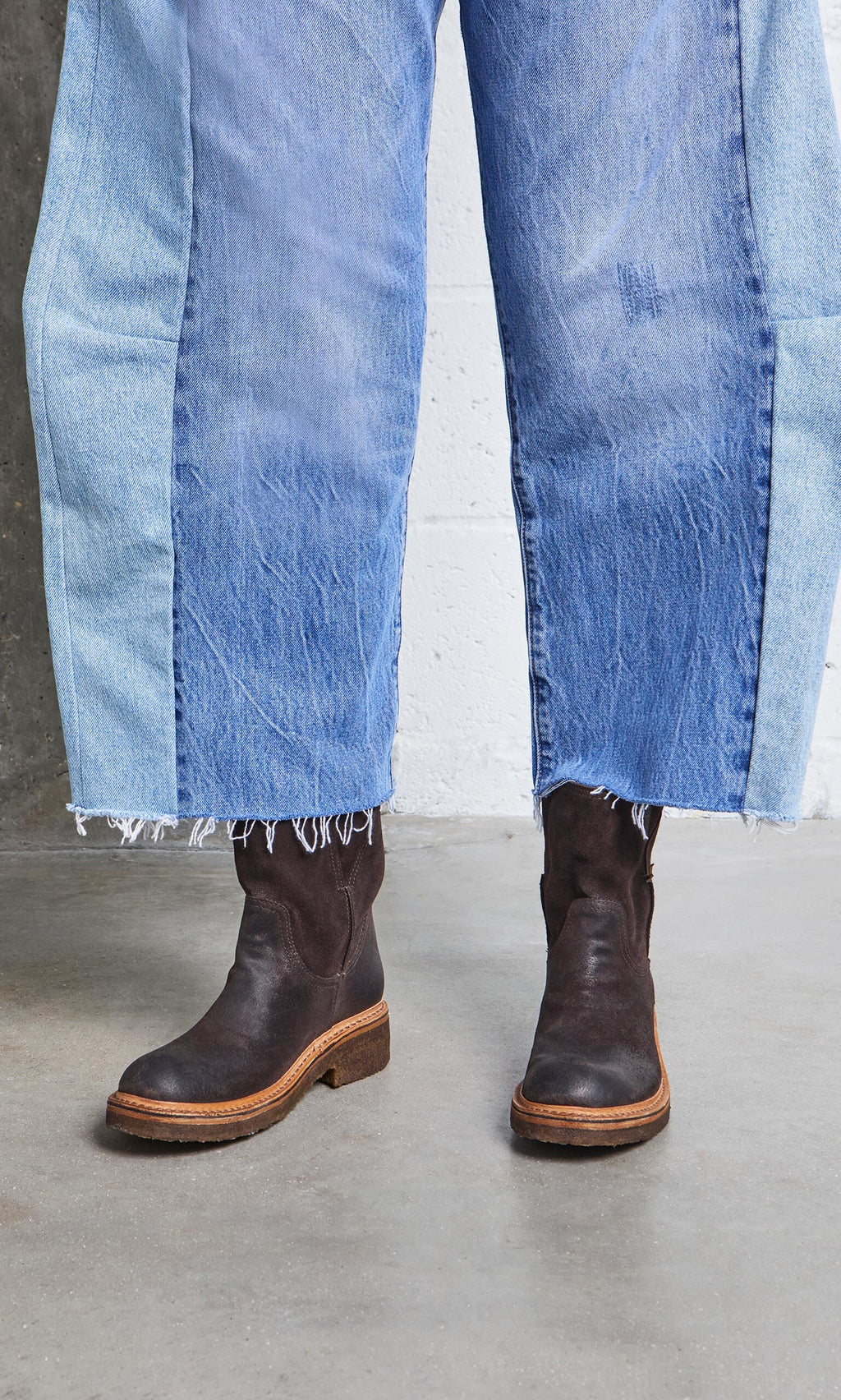 Plümo- Person wearing two-tone frayed jeans and Tait Boots, handcrafted in Italy from vegetable tanned leather.