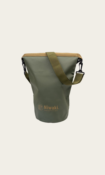 Plümo- Dry Bag - Green with tan trim and shoulder strap, shown on a plain light background.