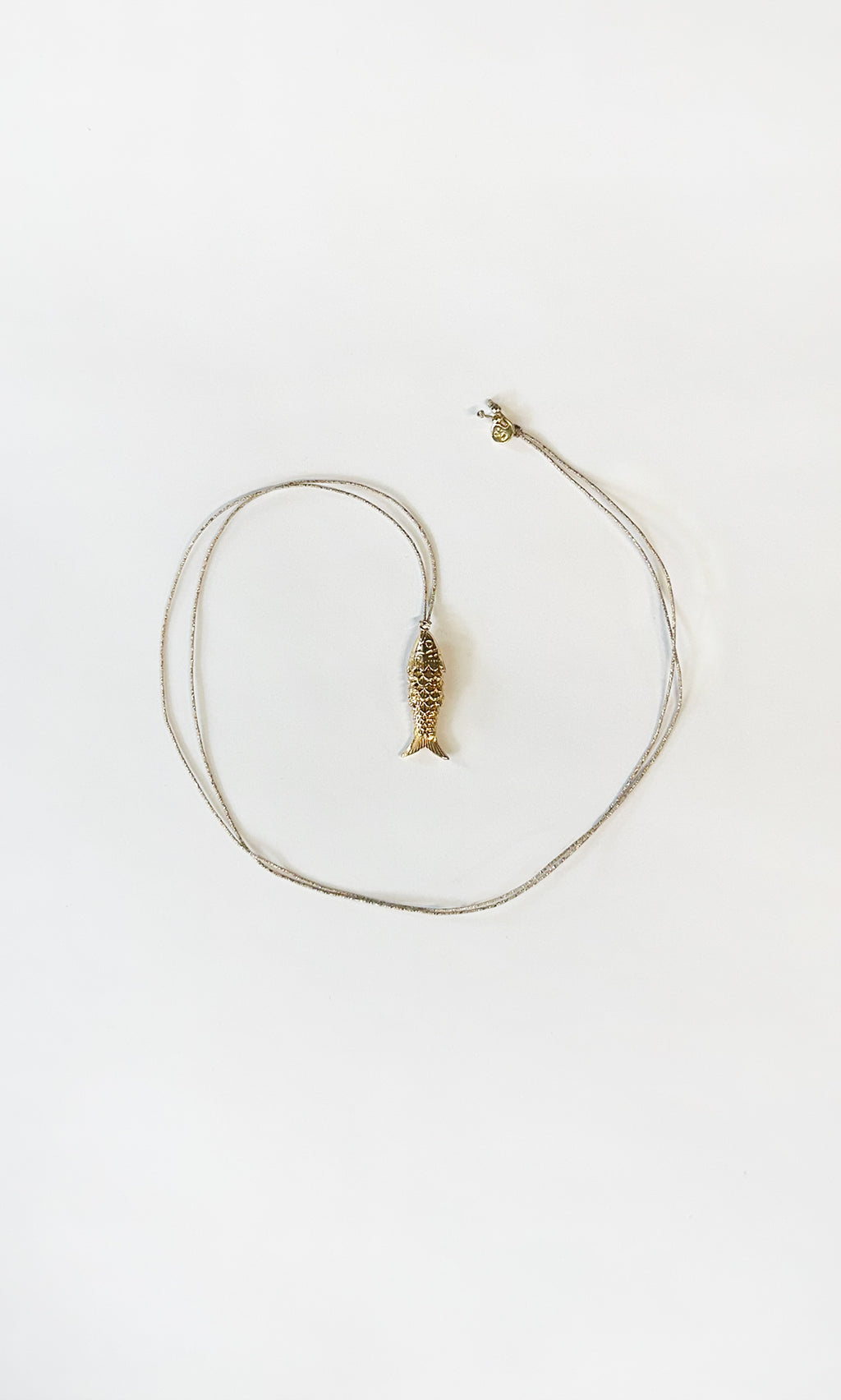 Plümo  The Celine Necklace is a gold-plated fish pendant, heart-shaped and adjustable—perfect for layering.