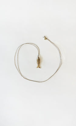 Plümo  The Celine Necklace is a gold-plated fish pendant, heart-shaped and adjustable—perfect for layering.